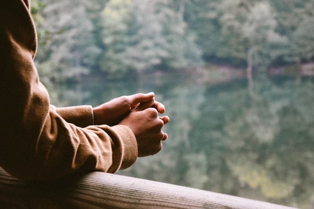 Woman looking out at lake while thinking