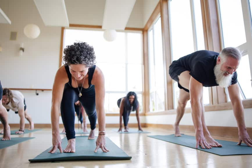 Man and woman doing yoga positions during a class