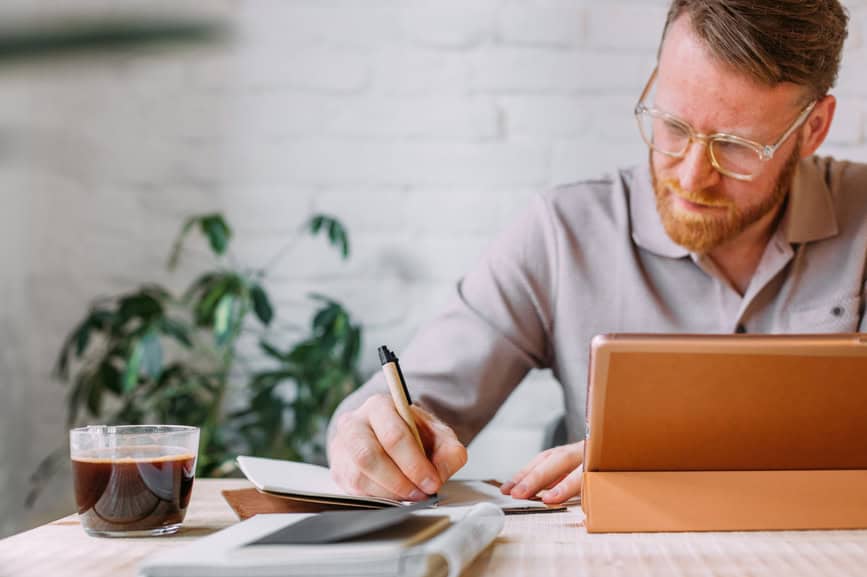 Man with glasses working on a laptop