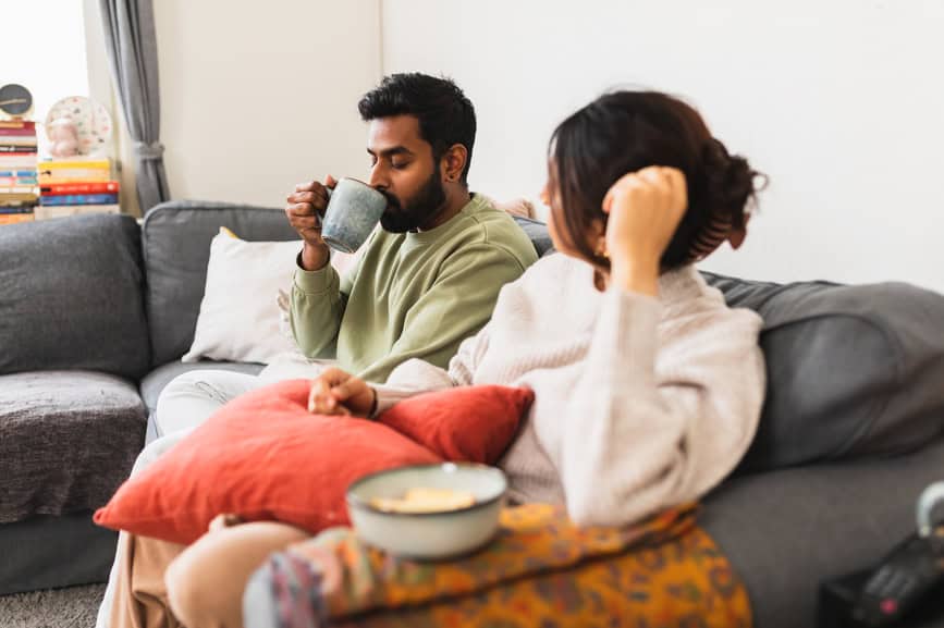 Couple enjoying drinking tea on couch while discussing sex therapy in Delaware