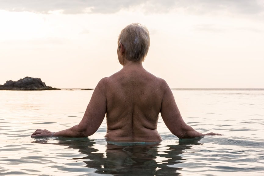Rear view of older woman swimming